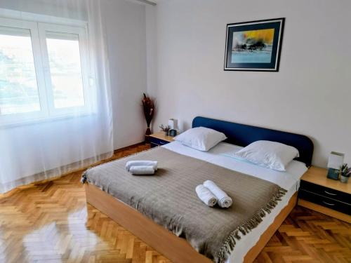 a bedroom with a bed with two towels on it at Apartments Kegalj in Podstrana