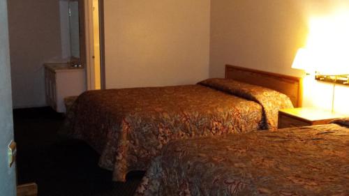 a hotel room with two beds and a lamp at National 9 Inn in Tonopah
