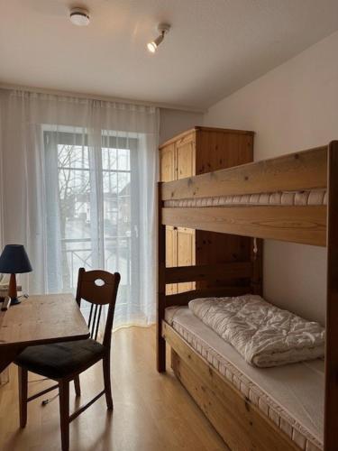 1 Schlafzimmer mit 2 Etagenbetten, einem Tisch und einem Stuhl in der Unterkunft Villa Seewind Wohnung 9 in Dahme