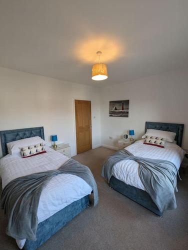 1 dormitorio con 2 camas y luz en New Fully equipped 2 bedroom house. Sleeps 6, en Brockhurst