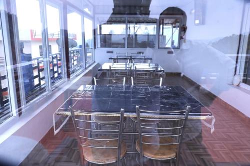 een eetkamer met een tafel en stoelen bij Cloud Nine Kothagiri By Lexstays in Kotagiri