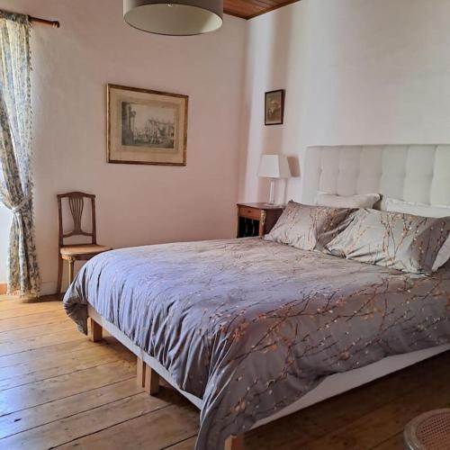 une chambre avec un grand lit dans une pièce dans l'établissement Gîte Le Pavillon dans le parc du Château Lescaut, à Montignac-de-Lauzun