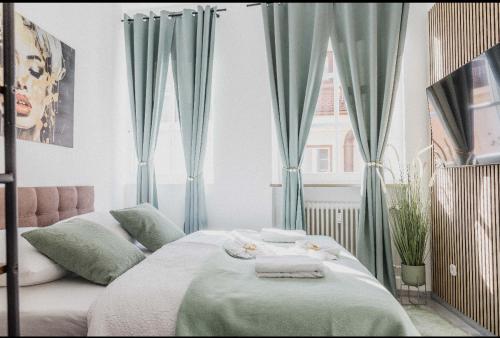 a bedroom with blue curtains and a bed with towels at Ferienwohnung Zentrum Erding in Erding