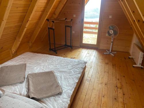 ein Schlafzimmer mit einem Bett und einem Ventilator im Dachgeschoss in der Unterkunft Vikendica Joža in Jajce