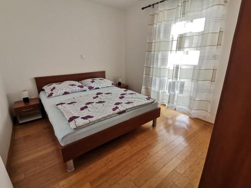 a bedroom with a bed and a window at Apartment Lučić in Poreč