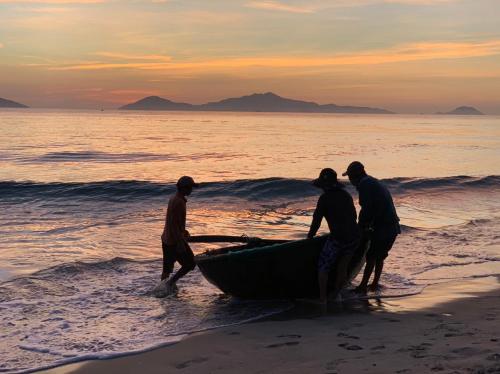 a group of people working on a boat on the beach at Santa Sea Villa in Hoi An