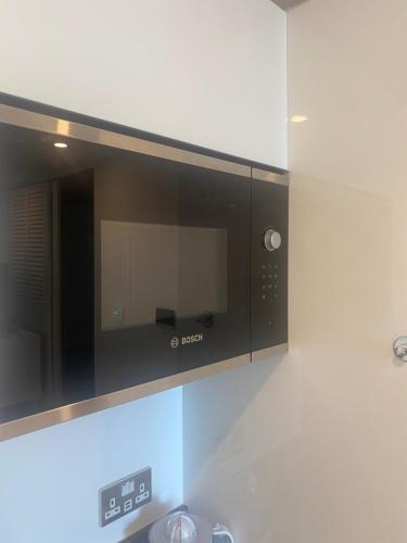a microwave oven hanging on a wall in a kitchen at CP Top floor luxury studio with spa and pool in Gibraltar