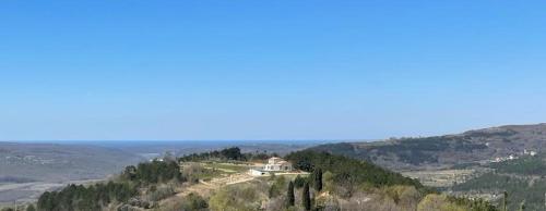 a house on the top of a hill with trees at Villa San Silvestro in Oprtalj