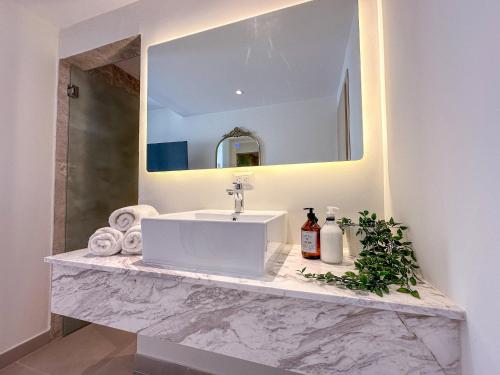 uma casa de banho com um lavatório branco e um espelho. em Cozy and beautiful apartment at the beach em Punta Cana