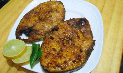 two pieces of food on a white plate with a lime at KENSONS BUDGETSTAY NON AC FREE WIFI and PARKING in Mangalore