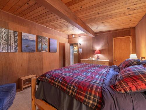 a bedroom with a bed in a wooden room at The Raccoon Shanty in Kings Beach