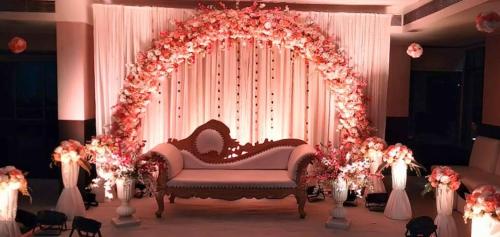 une arche de mariage avec un canapé dans une chambre avec des fleurs dans l'établissement GEETANJALI REGENCY, à kolkata
