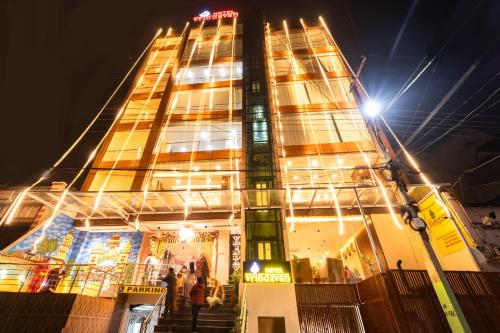 a tall building with people standing in front of it at night at HOTEL VRINDAVAN in Bīrganj
