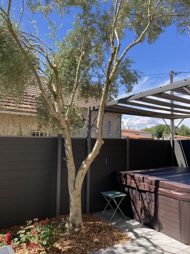 un arbre dans une cour à côté d'une clôture dans l'établissement Location appartement des Pyrénées, à Bordères-sur-lʼÉchez