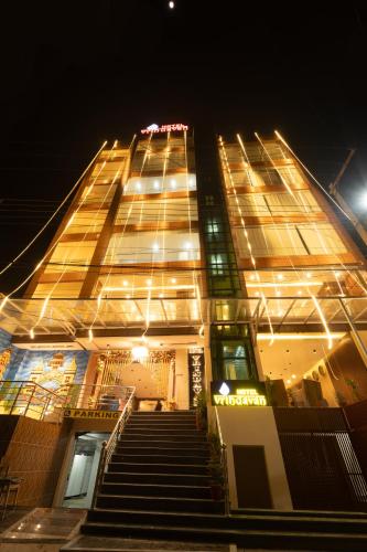 un grand bâtiment avec des escaliers devant lui la nuit dans l'établissement HOTEL VRINDAVAN, à Bīrganj