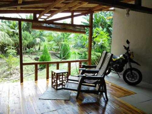 Un patio con una motocicleta estacionada en un porche. en Pauls Homestay, en Wado