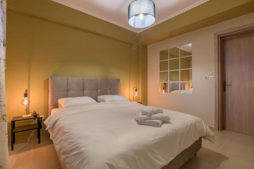 una camera da letto con un grande letto con asciugamani di Cosy Urban Escape a Alexandroupoli