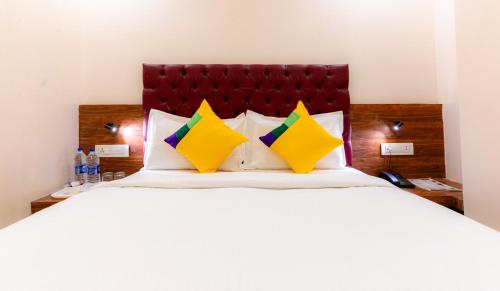 a bedroom with a large bed with yellow pillows at Itsy Hotels Elegant in Mumbai