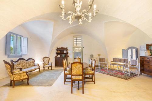 Habitación con mesa, sillas y lámpara de araña. en Masseria Pepe, en Torre Ovo
