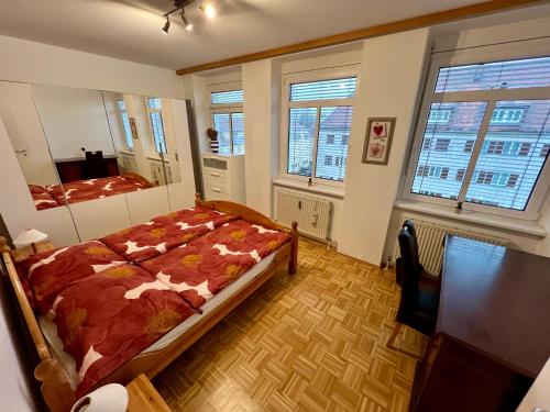 um quarto com uma cama num quarto com janelas em Helle freundliche Wohnung em Graz