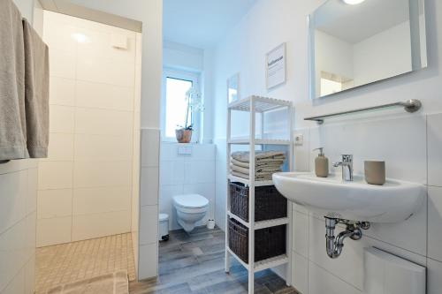 uma casa de banho branca com um lavatório e um WC em Modernes Business Apartment in Weyhe Nähe Bremen em Weyhe