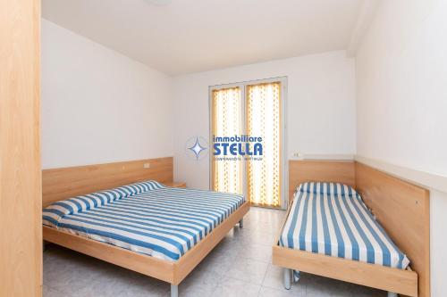 two beds in a room with a sign on the window at Residence Adriatica in Lido di Jesolo