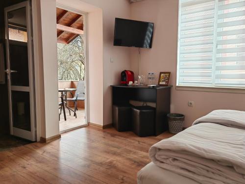 1 dormitorio con 1 cama y TV en la pared en стаи за гости TODA, en Troyan