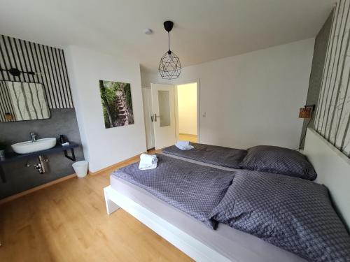 a bedroom with a large bed and a sink at Ferienhaus Am Reilsbach in Cochem