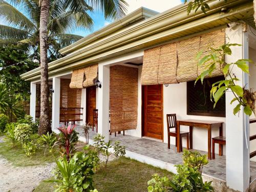 a house with a wooden door and a table at General's Hideout Siargao in General Luna