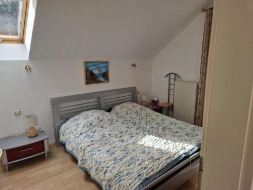 a bedroom with a bed with a blue comforter at Apartment Traunkai Zauner Blick in Bad Ischl