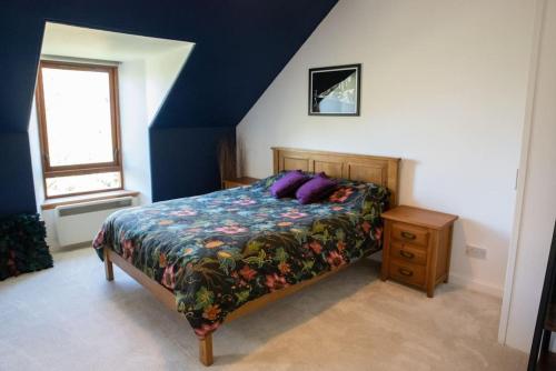Un dormitorio con una cama con almohadas moradas. en Stylish three-bedroom house in central Lerwick en Lerwick