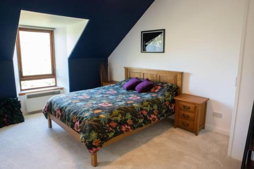 ラーウィックにあるStylish three-bedroom house in central Lerwickのベッドルーム1室(紫色の枕が付いたベッド1台付)