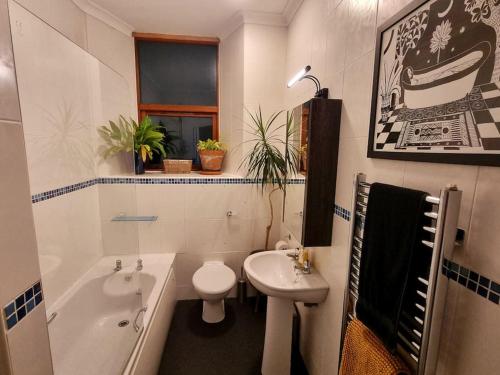 a bathroom with a sink and a toilet and a tub at Stylish three-bedroom house in central Lerwick in Lerwick
