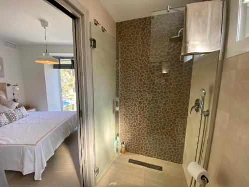 baño con ducha, cama y puerta de cristal en Brisa Puerto Marina Apartments, en Benalmádena