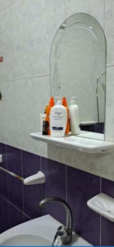 ein Bad mit einem Waschbecken und einem Spiegel in der Unterkunft الاسكندرية للضيافة in Alexandria