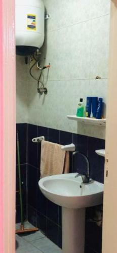 ein Bad mit einem weißen Waschbecken und einem Handtuch in der Unterkunft الاسكندرية للضيافة in Alexandria