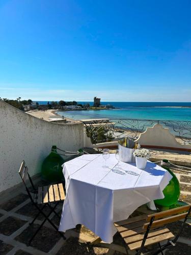 a white table with chairs and a view of the beach at Villa GAUDÌ in Sant'Isidoro