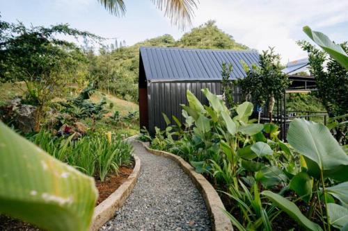a garden with a gravel path in front of a building at Grey Rock Mountain Cabin w/ Jacuzzi in Balamban