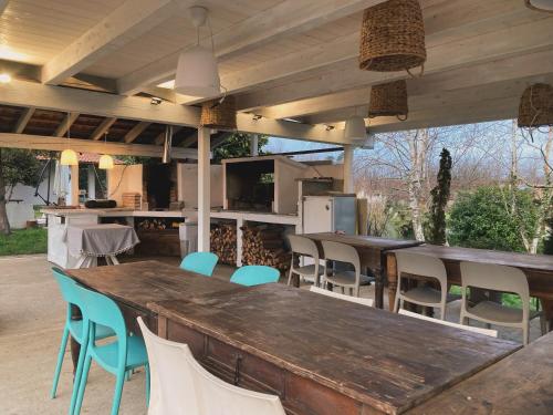 una cocina al aire libre con una gran mesa de madera y sillas en VILLA SELVA - Piemonte, en Agrate Conturbia