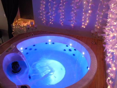 uma casa de banho com uma banheira com luzes de Natal em love room La gondole du plaisir em Saint-Pierre-dʼAmilly