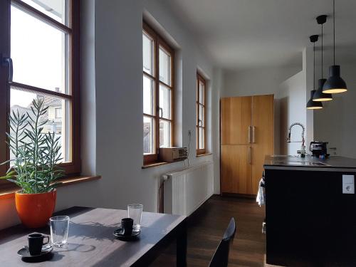 eine Küche mit einem Tisch und einigen Fenstern in der Unterkunft Haus Pinkafeld Top 3 in Pinkafeld