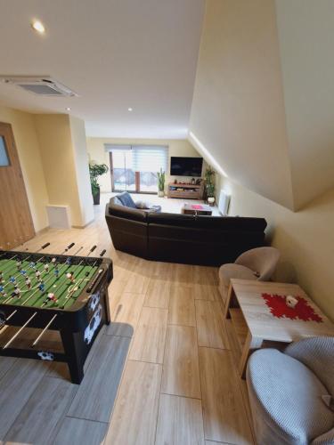 a living room with a pool table and a couch at Apartament u Rybaka in Sędki