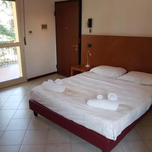 a bedroom with a large bed with towels on it at Il Rampicante-Monticelli Terme in Monticelli Terme