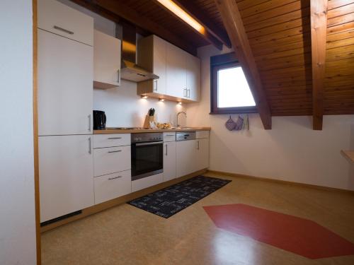eine Küche mit weißen Schränken und einem Fenster in der Unterkunft Schmidt`s Eppelborner Ferienwohnung in Eppelborn