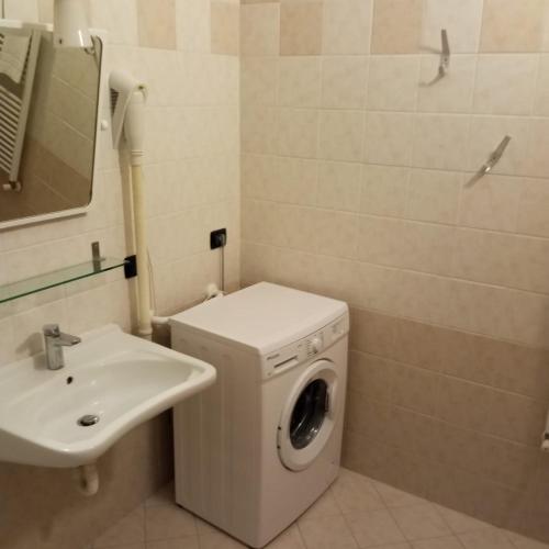 a bathroom with a washing machine and a sink at Il Rampicante-Monticelli Terme in Monticelli Terme