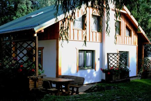 a house with a picnic table in front of it at Stajnia Sarnówek Nad Jeziorem Różany in Rozajny Wielkie