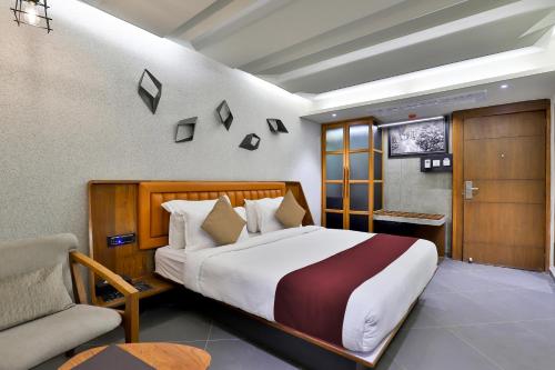 1 dormitorio con 1 cama grande y 1 silla en Keys Select by Lemon Tree Hotels, Gandhi Ashram, Ahmedabad en Ahmedabad