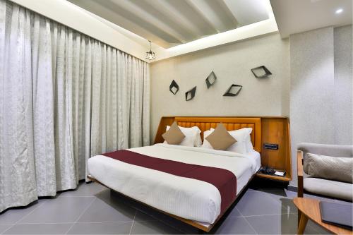 a bedroom with a large bed and a chair at Keys Select by Lemon Tree Hotels, Gandhi Ashram, Ahmedabad in Ahmedabad