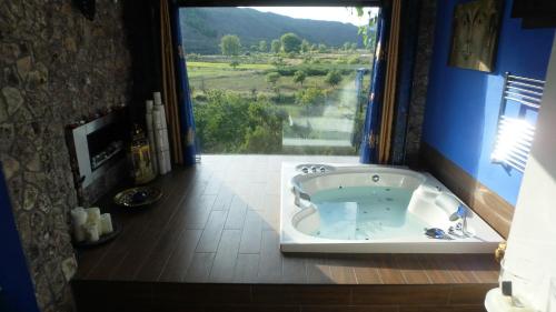 a bathroom with a tub with a large window at Suite Rural Carenas in Carenas