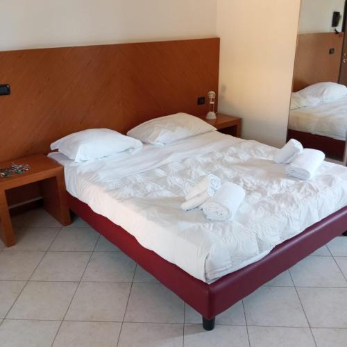 a bedroom with a bed with two white towels on it at Il Rampicante-Monticelli Terme in Monticelli Terme